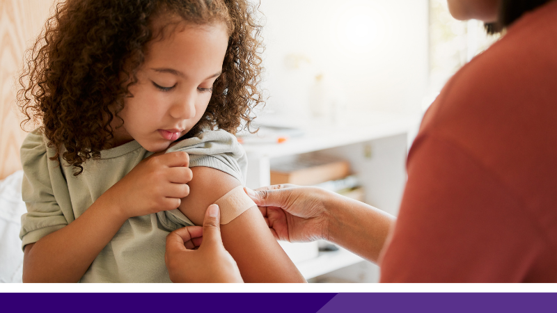 A child having a plaster put on their arm after a measles vaccination