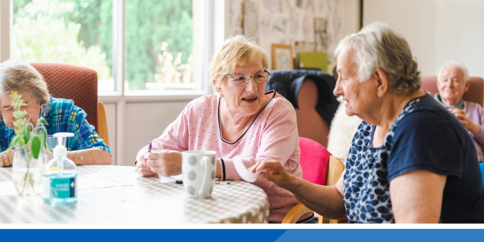 Two older females chatting with a cup of tea