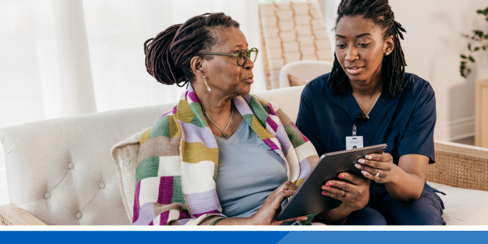 Medical professional explaining information to a patient who is looking at an electronic device